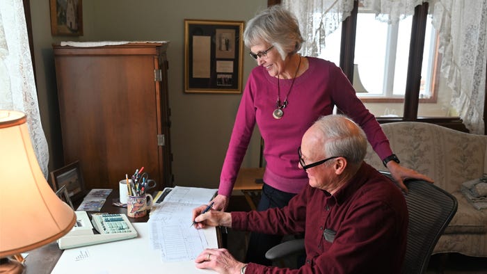 Mary and John Fischer at desk looking over paperwork