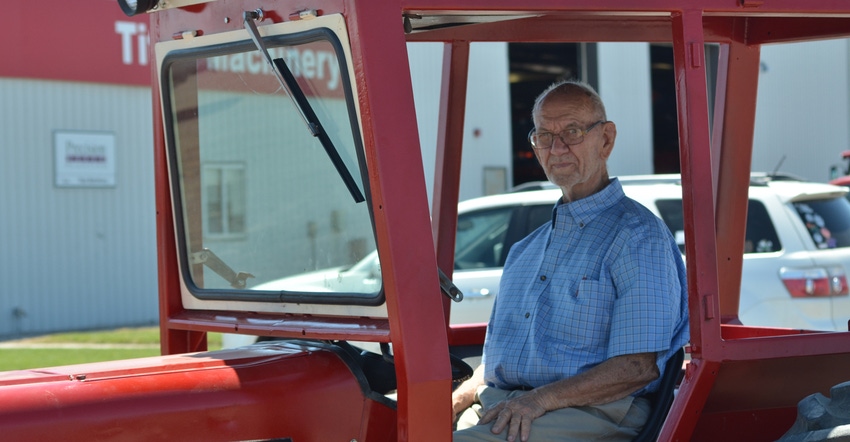 Dick Ourada sitting in the driver’s seat of his 1977 IHC 547 tractor 