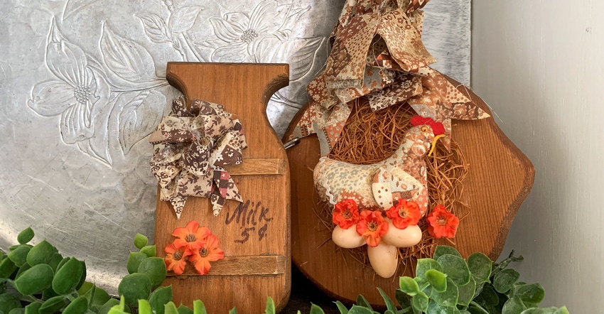 Fall themed decorations and a stuffed chicken adhered to a wooden board 
