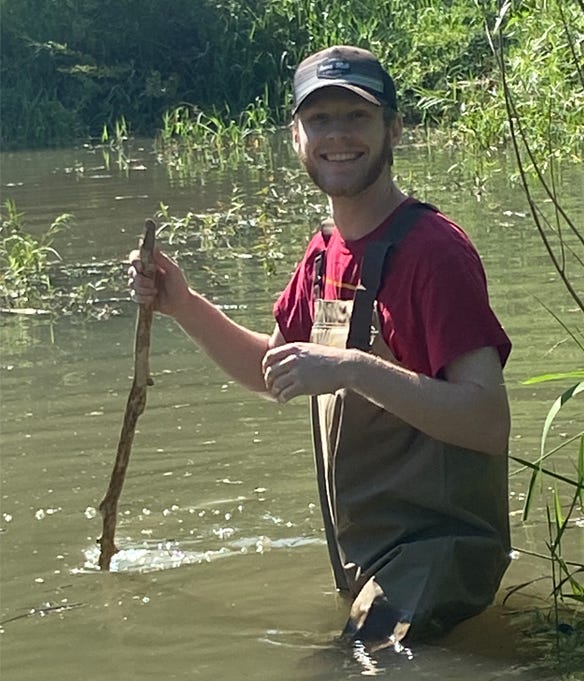 Intern Nathan Lewis conducting water field research in river