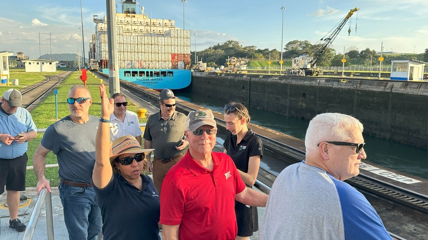  Onlookers watch as a container ship passes through the Panama Canal