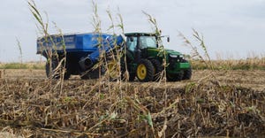 Tractor in drought damaged corn field during harvest