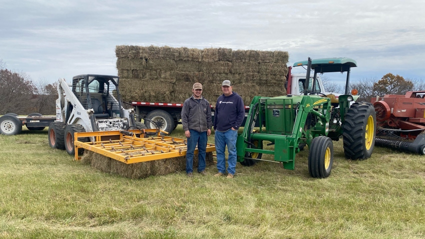Colton and Jeremy Kiso stand in front of their hay baling equipment and truck packed with hay bales