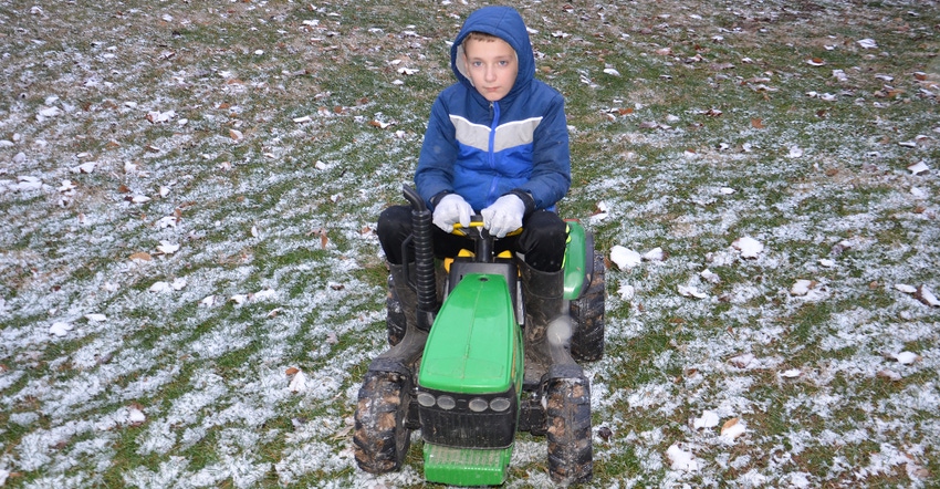 10-year-old Graham riding on tiny John Deere tractor 10-year-old Graham riding on tiny John Deere tractor