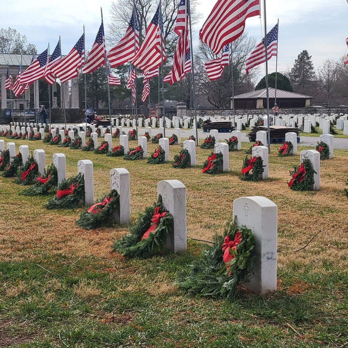 MU Extension - Wreaths with red bows line headstones at a cemetery with American flags flying at full-staff