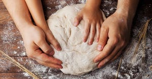 Adult and child hands prepares the dough with flour