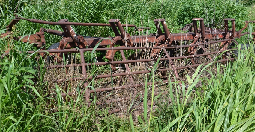 old rusted plow in field