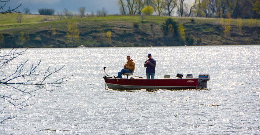 Two men on a boat fishing on a lake
