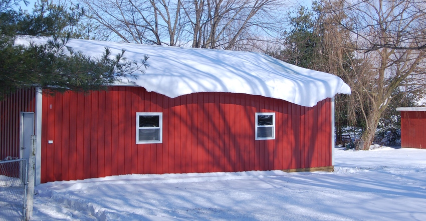 red pole barn covered in snow