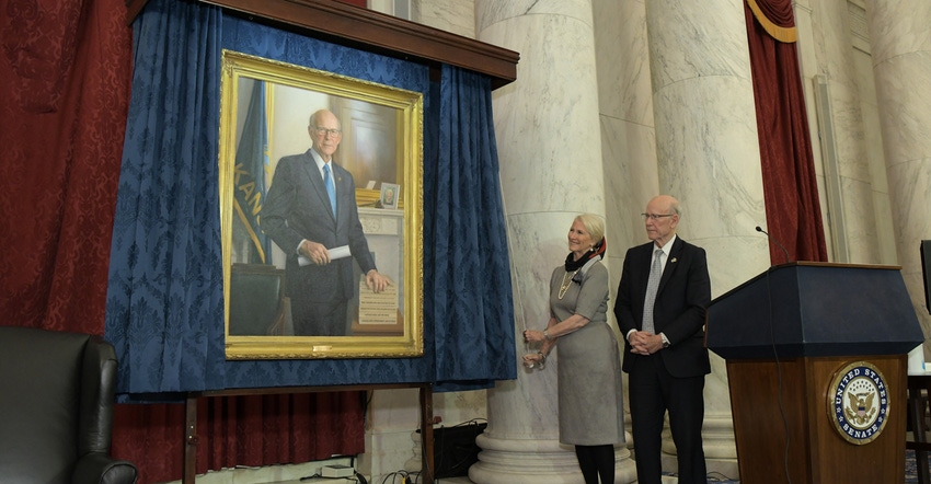 Sen. Pat Roberts, right, watches as his wife, Fanki, pulls the cord to unveil his official portrait to be displayed in the Se