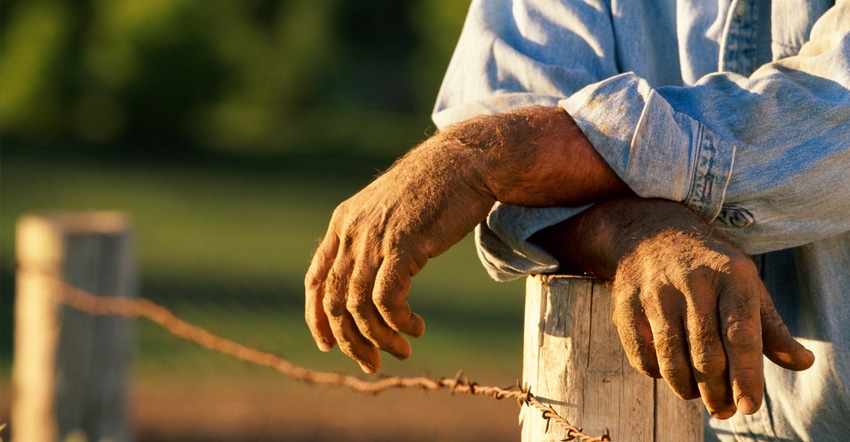 Farmer leaning on fence