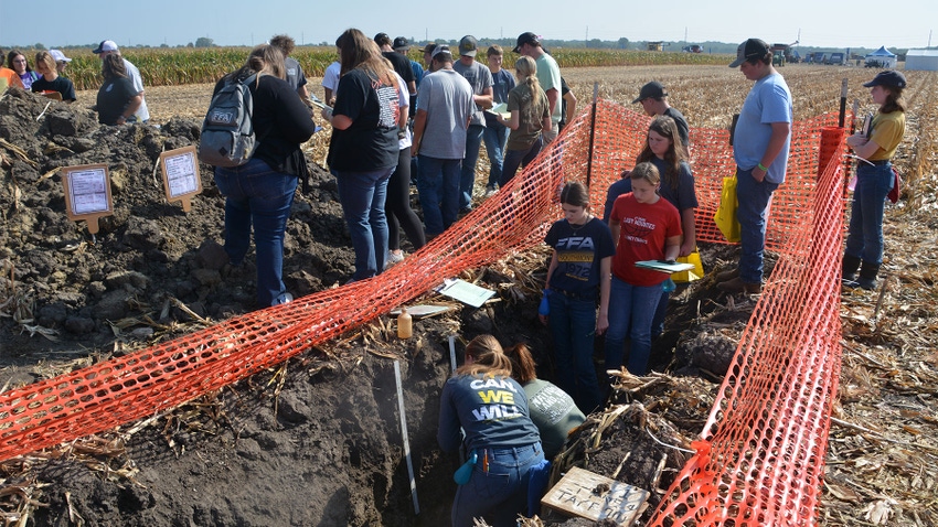 A large group of people in and around a soil pit