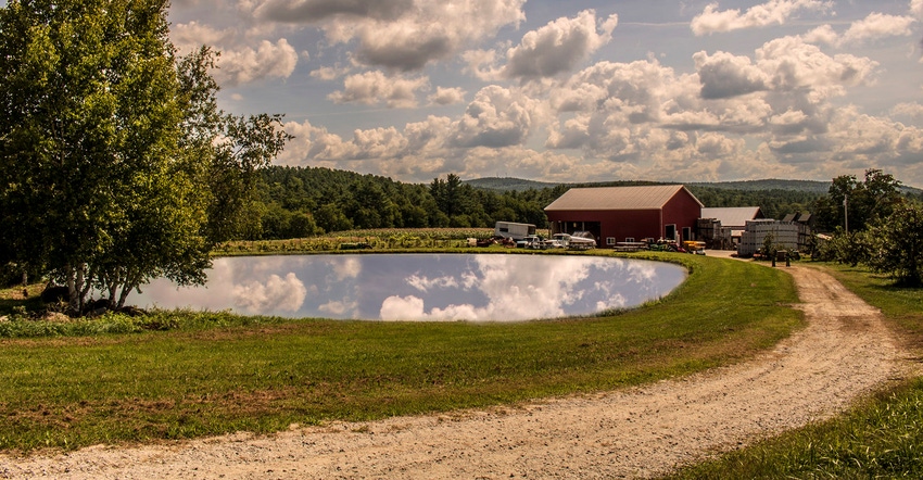 The crystal clear pond at the Apple Hill Farm in Concord, NH, reflects the sky above.