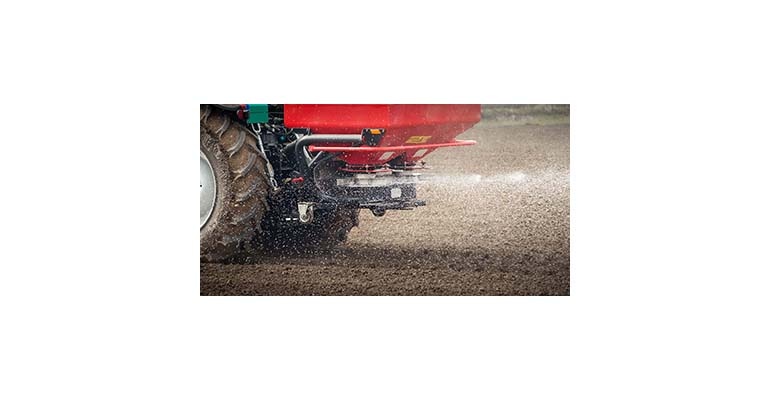 Tractor and fertilizer spreader in field