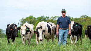 Norris Sloan, Missouri diary farmer in a field with Holstein cows