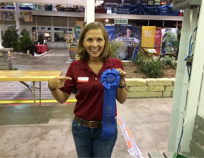 Meaghan Anderson holding blue ribbon for weed ID contest