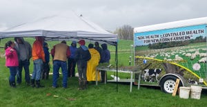 Farmers gather under a tent near the New York Soil Health Trailer