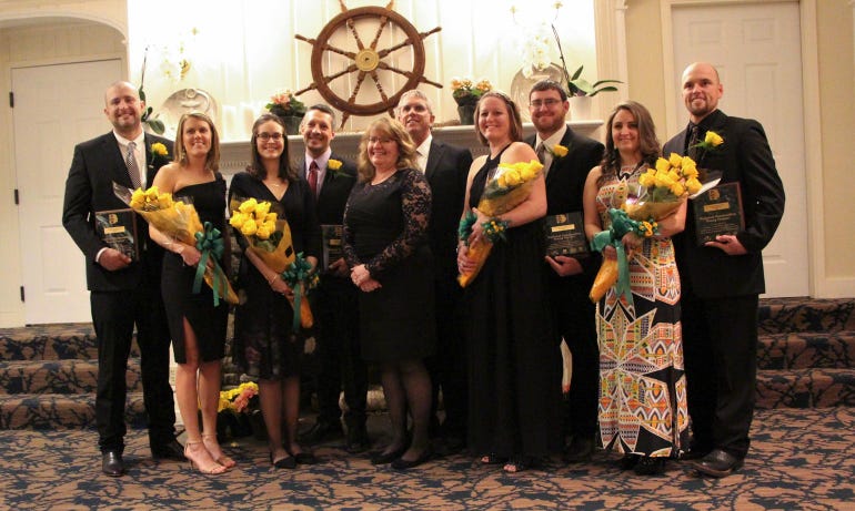 Pictured are Greg and Carmen Bendixson, Brandon and Ashley Bonk, Maria and Doug Bichler, Mary Beth and Michael Jackson, and Heather and Will Cabe all holding flowers and award plaques