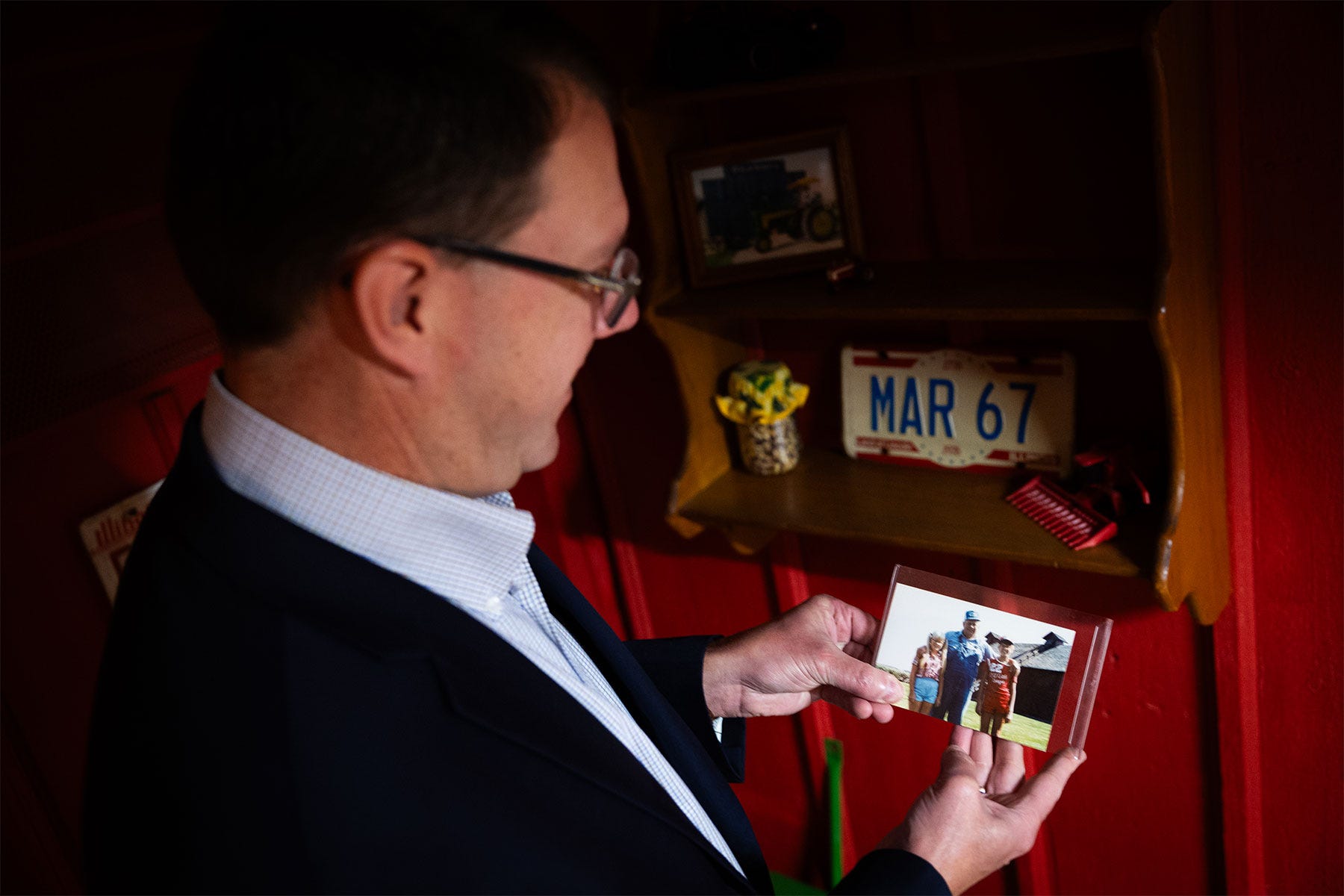 man looks at a photograph he's holding in his hands