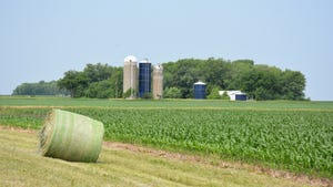 Farmscape with cornfield and hay bale