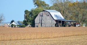 A barn next to a soybean field ready for harvest