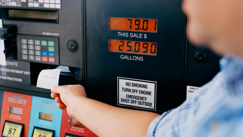 man grabbing receipt from gas station pump