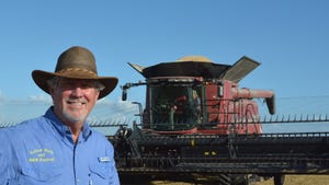 man standing in front of a rice combine