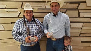 Woman and man with son, adults holding belt buckle awards 