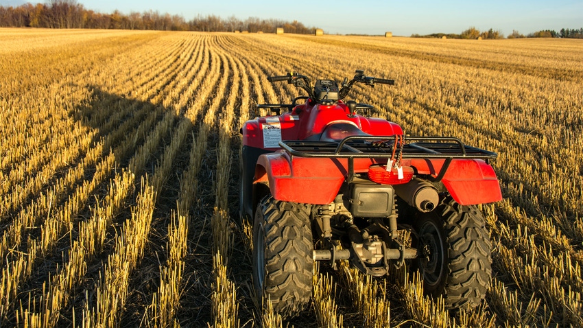  red ATV in a harvested wheat field