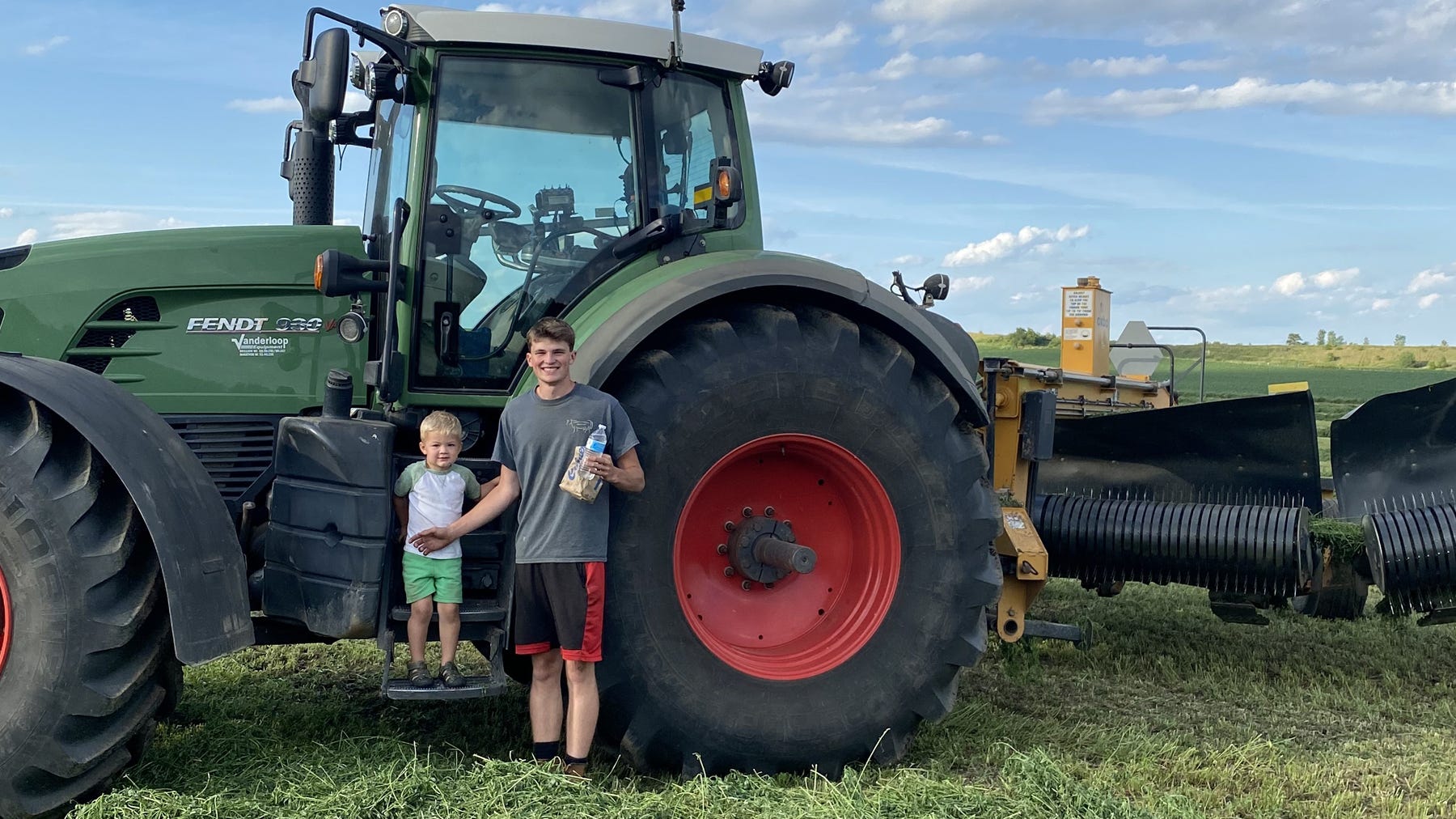  Leo and Gavin Maier on the farm near Waunakee standing next to a tractor