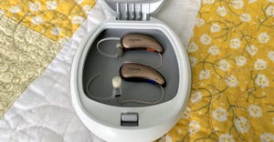 Hearing aids in a case sitting on a patterned and quilted background