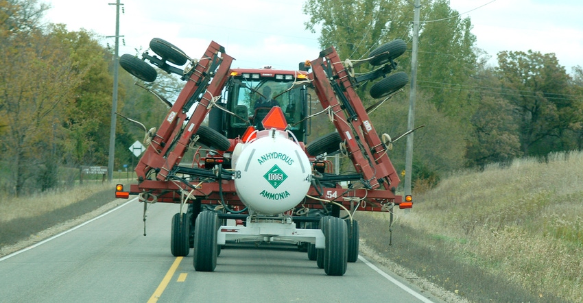anhydrous tank behind a tractor on highway