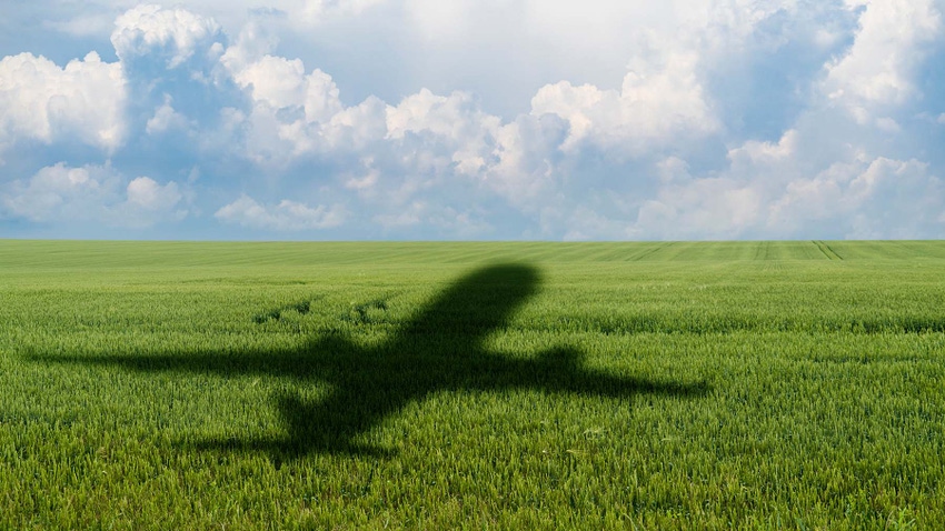 Shadow of plane flying over green agriculture field