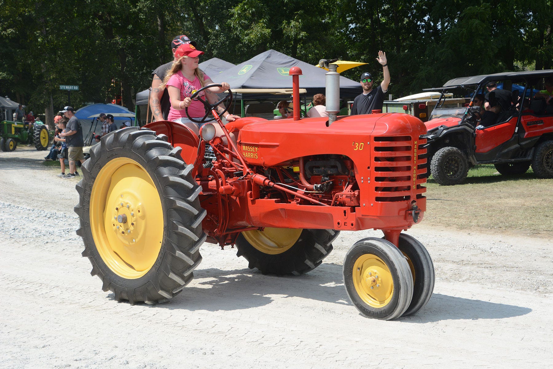 A woman driving a Massey-Harris 30 tractor in a parade