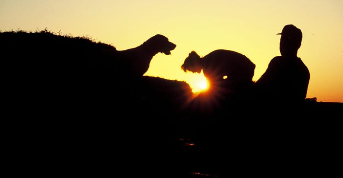 silhouette of farmers and dog