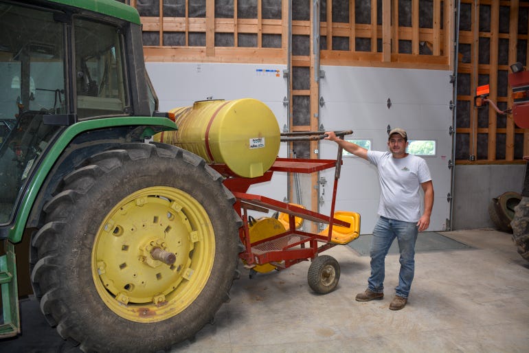 Harnish stands beside his water-wheel planter pulled by a John Deere 6410