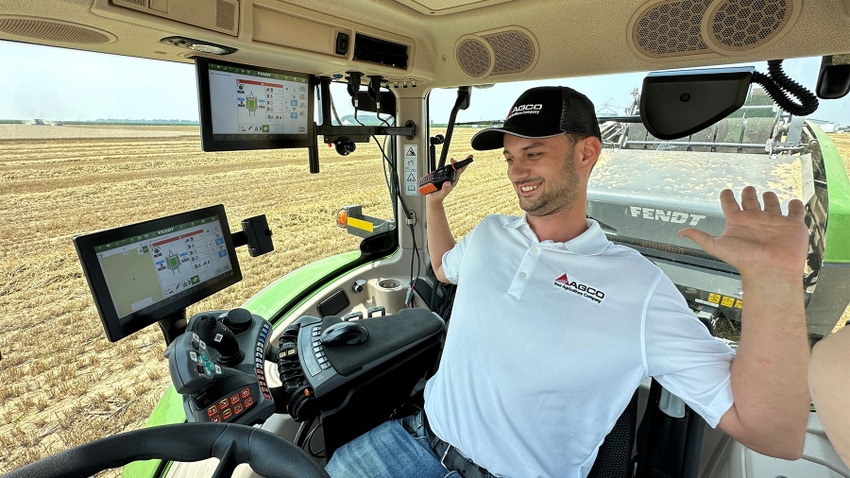  A man in an autonomous tractor with his hands off of the steering wheel