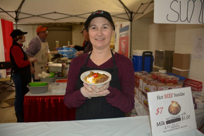A vendor holds up a hot beef sundae at the New York Farm Show