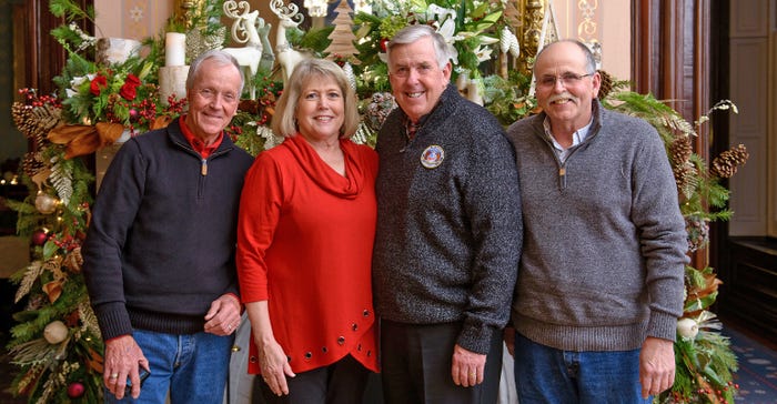 Missouri Governor Mike Parson and First Lady Teresa Parson stand with the governor's brothers, Kent and Jim Parson, surrounded by holiday decorations at the Governor's Mansion