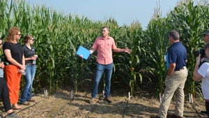 Kyle Mohler presenting to a crowd in front of a corn field