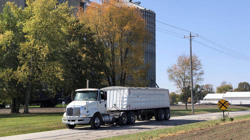  A tractor trailer driving by a railroad crossing sign