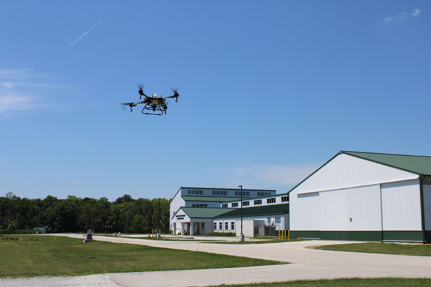 a drone flies in the sky with white buildings in the background