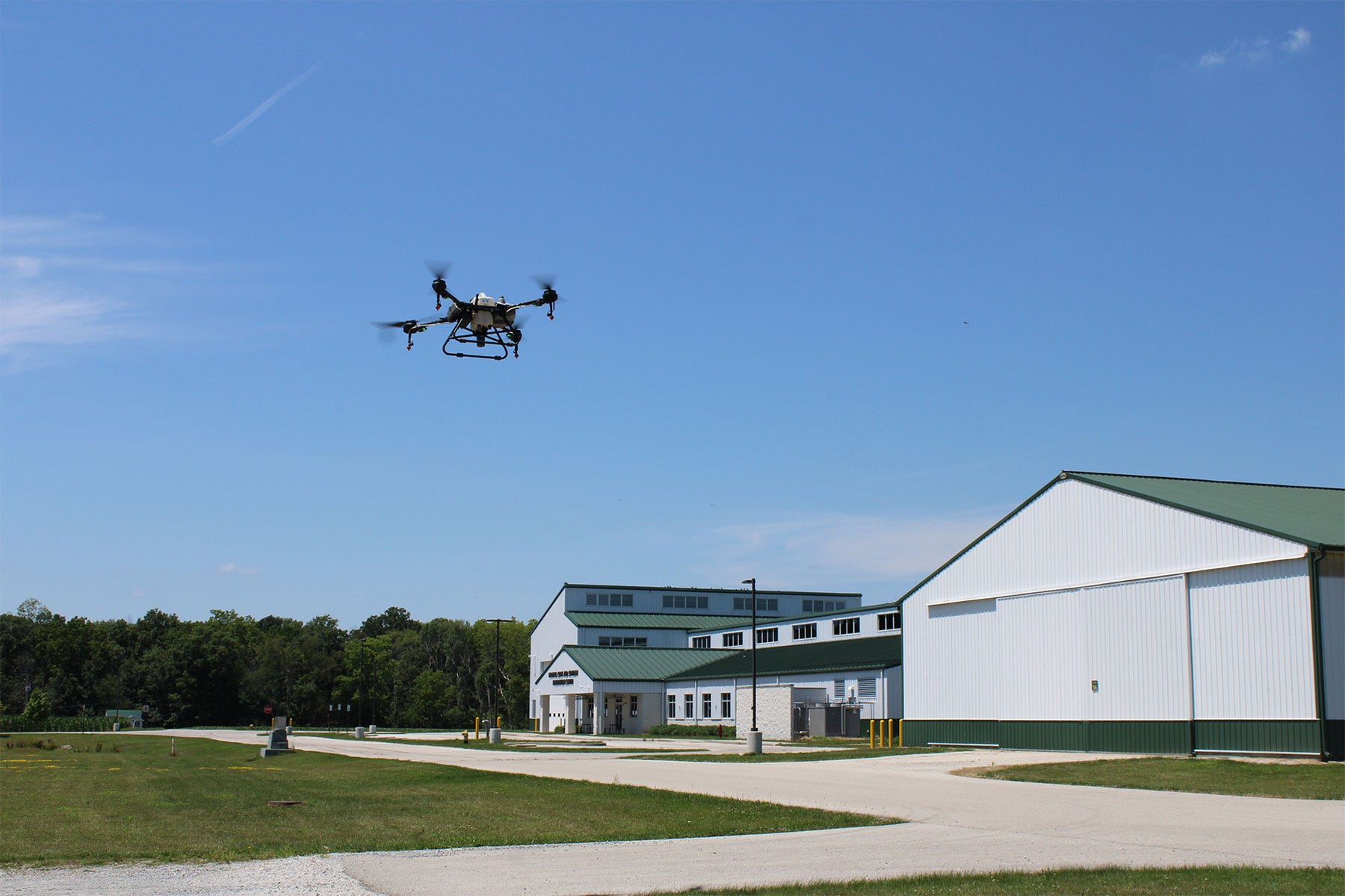 a drone flies in the sky with white buildings in the background a drone flies in the sky with white buildings in the background
