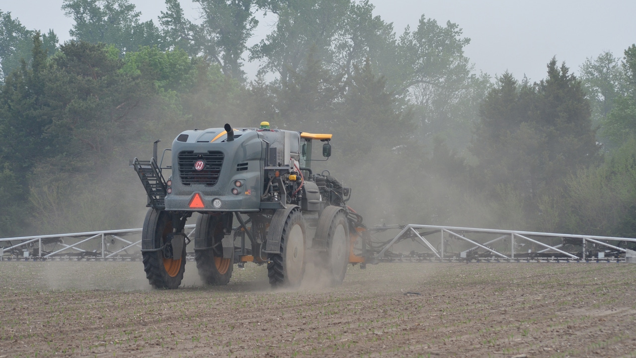 Tractor spraying chemicals on field