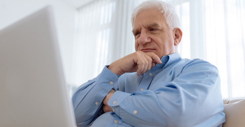 White haired man with laptop