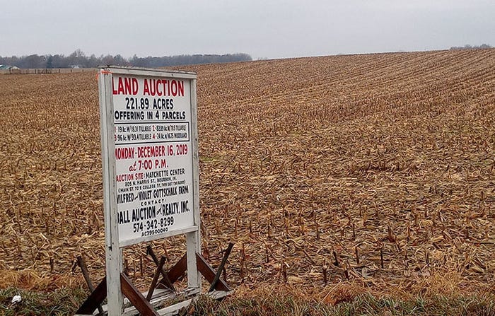 Land auction sign in a field