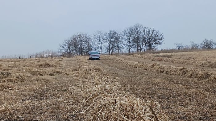 Truck driving on field of windrows