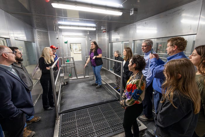 A group touring a cow methane measurement facility