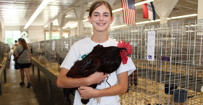 Taylor McCarty holding a rooster at the Missouri State Fair