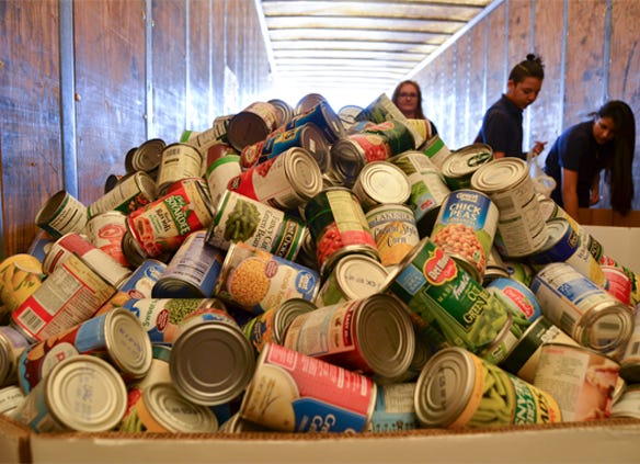 Boxes are filled to overflowing with cans donated by FFA members during the Heartland United Way Food 4 Families food drive at HHD. 